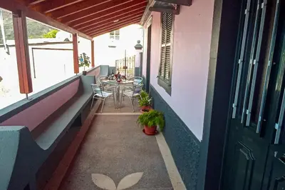 a balcony of a house with a table and chairs at The funny and Relax apartment with terrace & view in Arco da Calheta