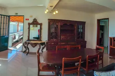 a dining room with a wooden table and a mirror at The funny and Relax apartment with terrace & view in Arco da Calheta