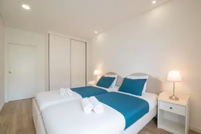 a bedroom with a large white bed with blue pillows at Luz Secret by MOJE Holiday in Luz