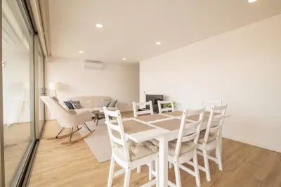 a white dining room with a table and chairs at Luz Secret by MOJE Holiday in Luz