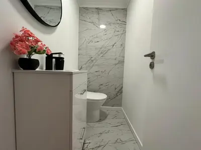 a white bathroom with a toilet and a mirror at Center Funchal - Rooms For Rent in Funchal