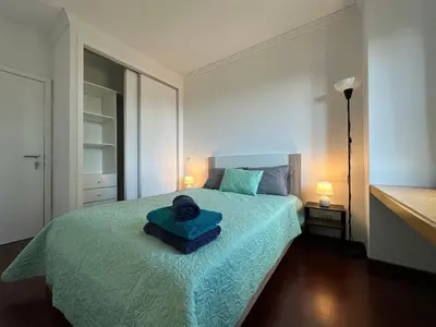 a bedroom with a bed with a blue blanket at Center Funchal - Rooms For Rent in Funchal