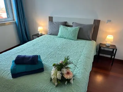 a bedroom with a bed with flowers on it at Center Funchal - Rooms For Rent in Funchal