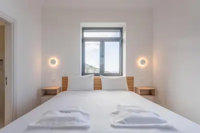 a bedroom with a white bed with two towels on it at FLH Papaya Villa with Sea View in Funchal