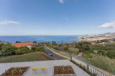 a balcony with two chairs and a view of the ocean at FLH Papaya Villa with Sea View in Funchal