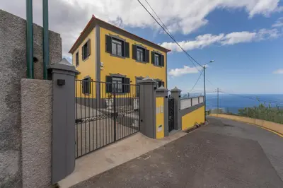 a yellow house with a gate on a street at FLH Papaya Villa with Sea View in Funchal