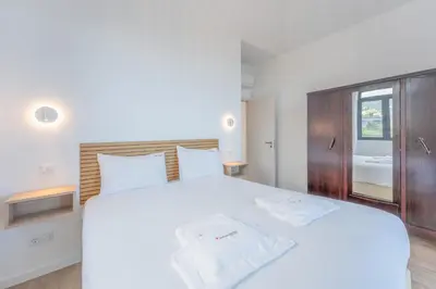 a bedroom with a white bed and a window at FLH Papaya Villa with Sea View in Funchal