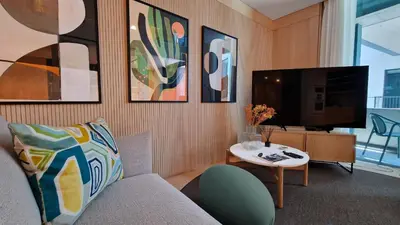 a living room with a couch and a tv and a table at The Urban Retreat by LovelyStay in Funchal