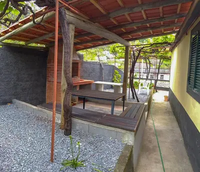 a patio with a picnic table and a bench at Typical Farm Apartment in Arco da Calheta