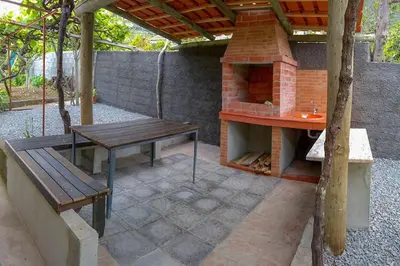 a patio with a table and a brick oven at Typical Farm Apartment in Arco da Calheta