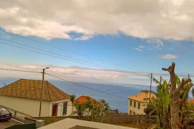 a view of the ocean from a house at Typical Farm Apartment in Arco da Calheta