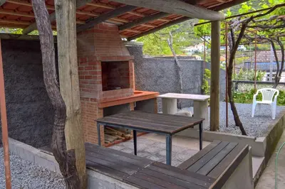a patio with a wooden table and a bench at Typical Farm Apartment in Arco da Calheta