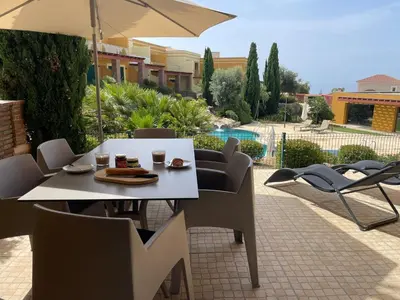 a table and chairs and an umbrella on a patio at No14 Lote B, Quinta da Belavista in Luz