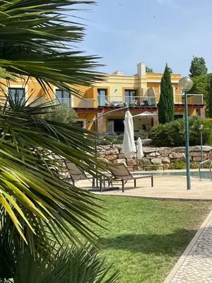 a park with two benches and a building at No14 Lote B, Quinta da Belavista in Luz