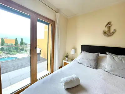 a bedroom with a bed and a large window at No14 Lote B, Quinta da Belavista in Luz