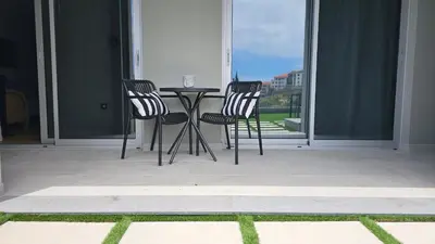 two chairs and a table on a patio with a window at Magnólia Residence in Funchal