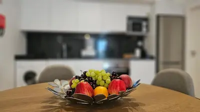 a bowl of fruit on a wooden table at Magnólia Residence in Funchal