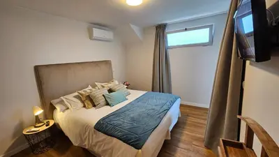 a bedroom with a large bed and a window at Magnólia Residence in Funchal