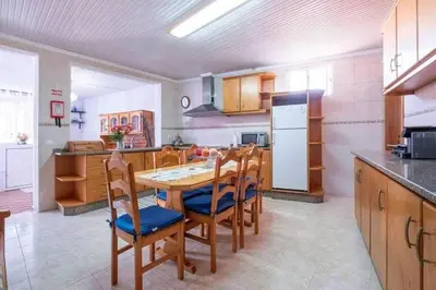 a kitchen with a table and chairs and a refrigerator at Casa Fonte do Serrado in Caniçal