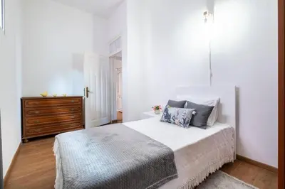 a white bedroom with a bed and a dresser at Casa Fonte do Serrado in Caniçal