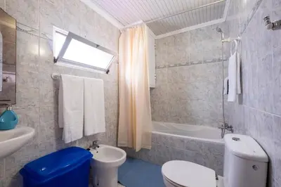 a bathroom with a toilet and a sink and a tub at Casa Fonte do Serrado in Caniçal
