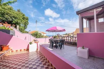 a patio with a table and an umbrella at Casa Fonte do Serrado in Caniçal
