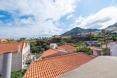 a view of a town with roofs and mountains at Casa Fonte do Serrado in Caniçal