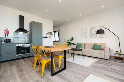 a kitchen and living room with a table and yellow chairs at The View Flat by Rent-a-key in Funchal