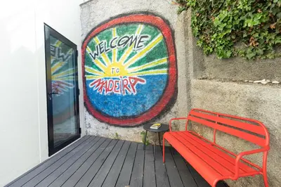 a red bench sitting next to a wall with a sign at The View Flat by Rent-a-key in Funchal