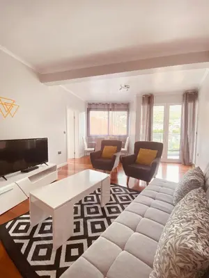 a living room with a couch and chairs and a tv at Village Square Coastal Apartment 3G in Machico