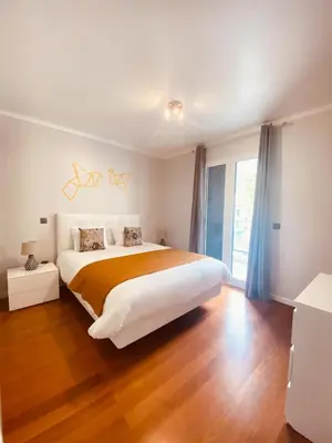 a bedroom with a large bed and a large window at Village Square Coastal Apartment 3G in Machico