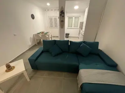 a blue couch in a living room with a table at Villa Do Calo in Sagres