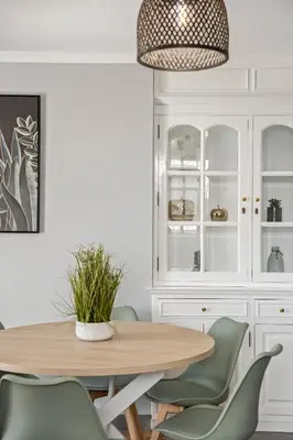 a dining room with a wooden table and green chairs at Villa Pedreiro in Funchal