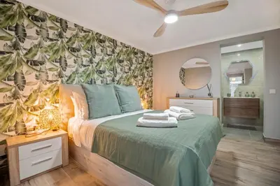 a bedroom with a bed and a bathroom with a mirror at Villa Pedreiro in Funchal