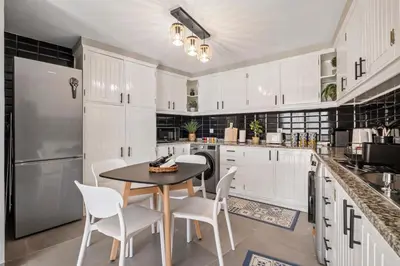 a kitchen with white cabinets and a table and chairs at Villa Pedreiro in Funchal