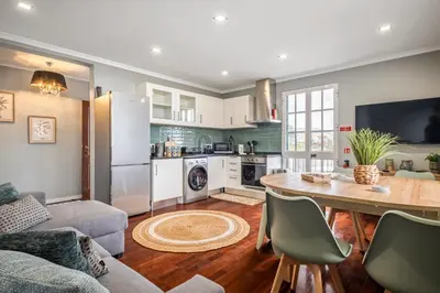 a kitchen and living room with a table and chairs at Villa Pedreiro in Funchal