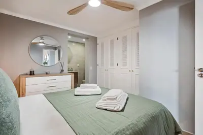 a white bedroom with a bed with towels on it at Villa Pedreiro in Funchal