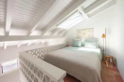 a bedroom with a bed and a skylight at Casa Primeira in Vila do Bispo