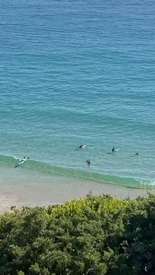 a group of people surfing in the ocean at Casa Primeira in Vila do Bispo