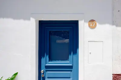 a blue door on the side of a building at Casa Primeira in Vila do Bispo