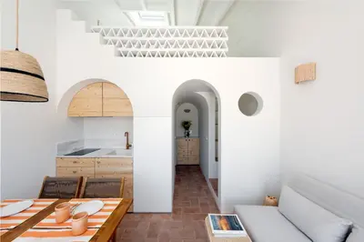 a kitchen and dining room with white walls and a table at Casa Primeira in Vila do Bispo