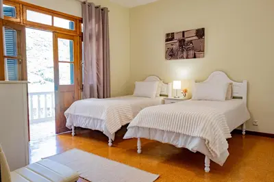 two beds in a room with a window at São Vicente Guest House in São Vicente