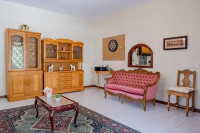 a living room with a pink couch and a table at São Vicente Guest House in São Vicente