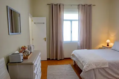 a hotel room with a bed and a window at São Vicente Guest House in São Vicente