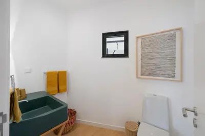 a bathroom with a green sink and a window at Lazareto Sea View by An Island Apart in Funchal