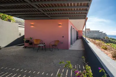 a patio with chairs and a pink wall at Lazareto Sea View by An Island Apart in Funchal