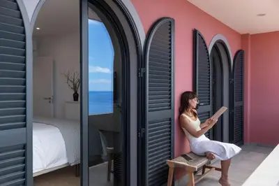 a woman sitting on a chair in a room with a window at Lazareto Sea View by An Island Apart in Funchal
