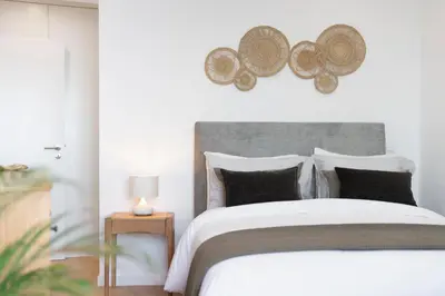 a bedroom with a large white bed with black pillows at Lazareto Sea View by An Island Apart in Funchal