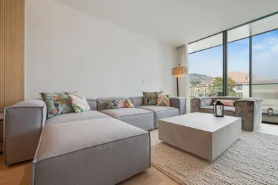 a living room with a couch and a table at Chic Two-Bedroom En Suite in Central Town - Savoy Residence in Funchal