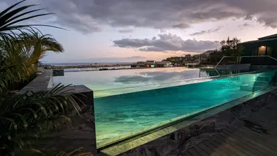a large swimming pool with the ocean in the background at Chic Two-Bedroom En Suite in Central Town - Savoy Residence in Funchal